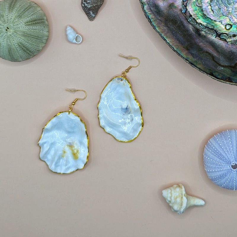 Pair of white oyster-shell earrings with gold edges